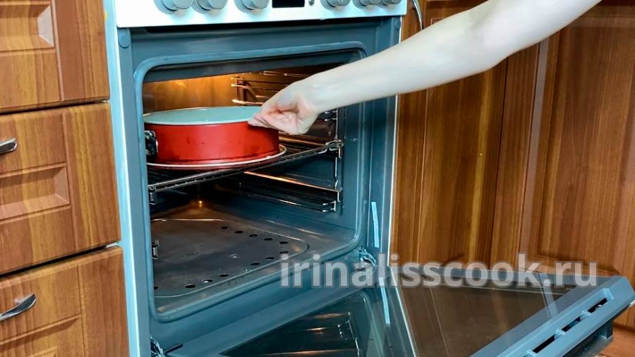 женская рука ставит форму для выпекания в духовку